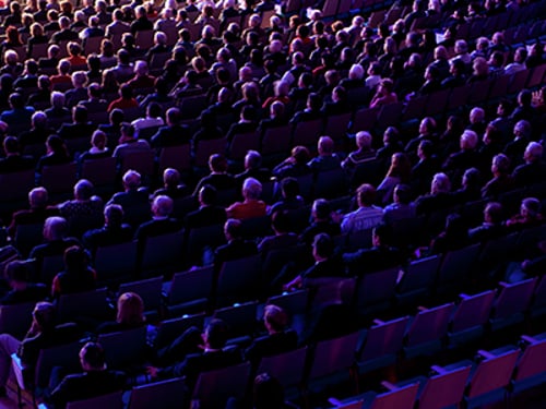 Seated audience in a theater.